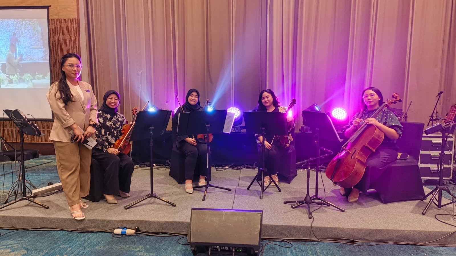 Farah Li with a string ensemble on stage at an event
